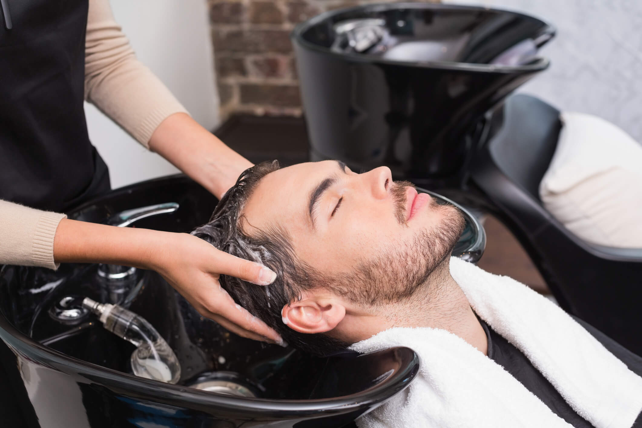 Male client hair being washed in salon chair