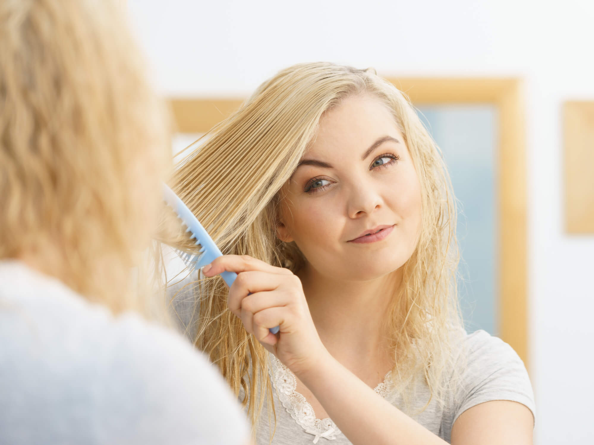 blonde woman combing hair
