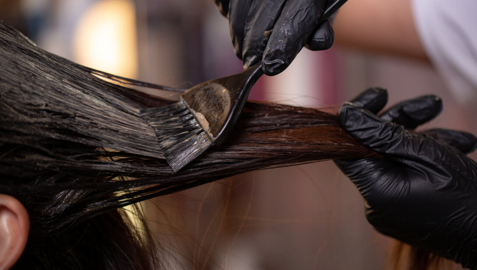 Image of a stylist coloring the client's hair