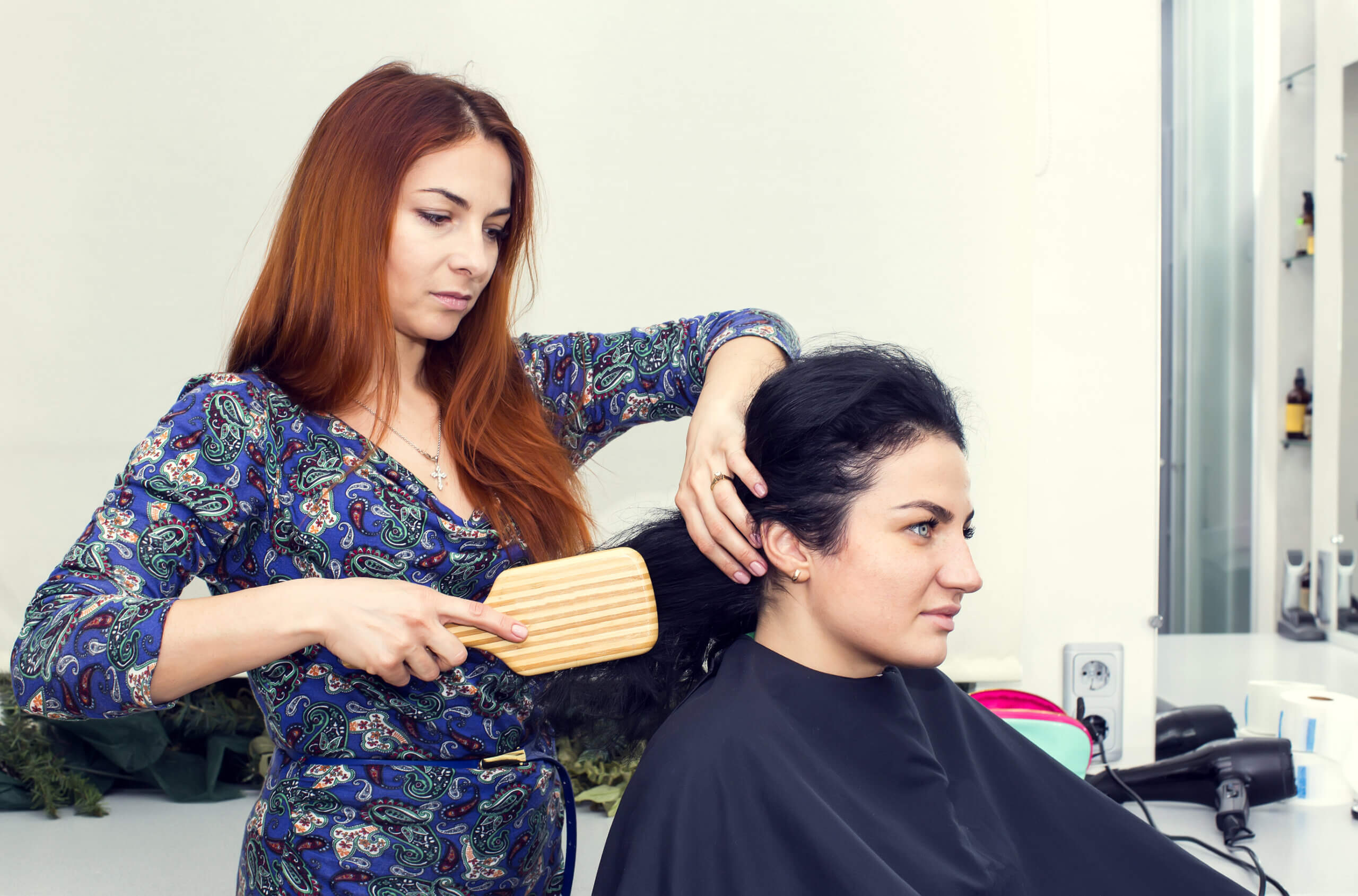 hairstylist brushing client's hair