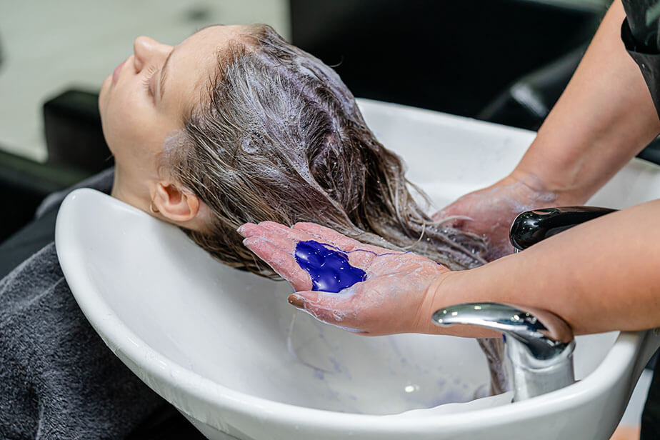 stylist using purple shampoo