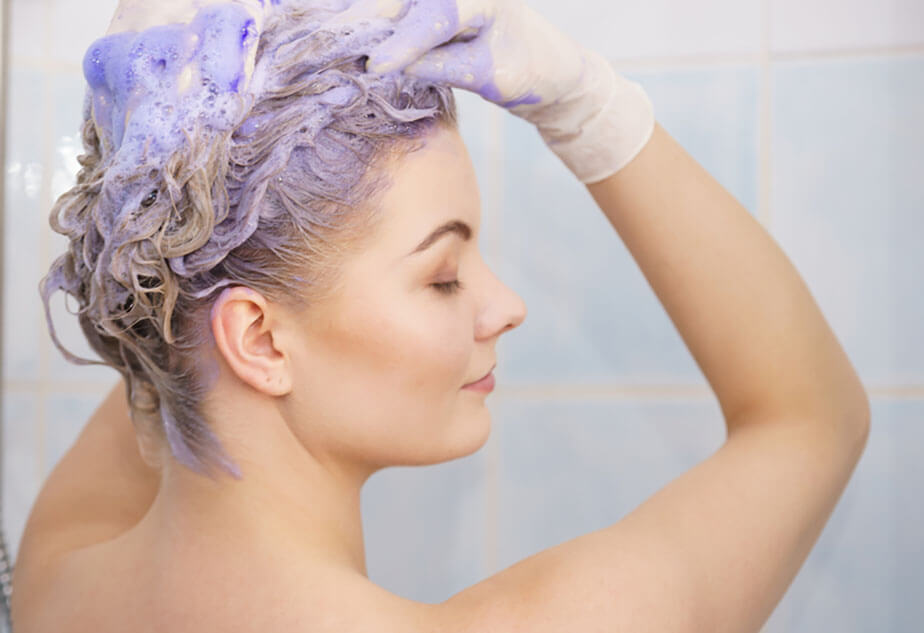 applying purple shampoo to hair