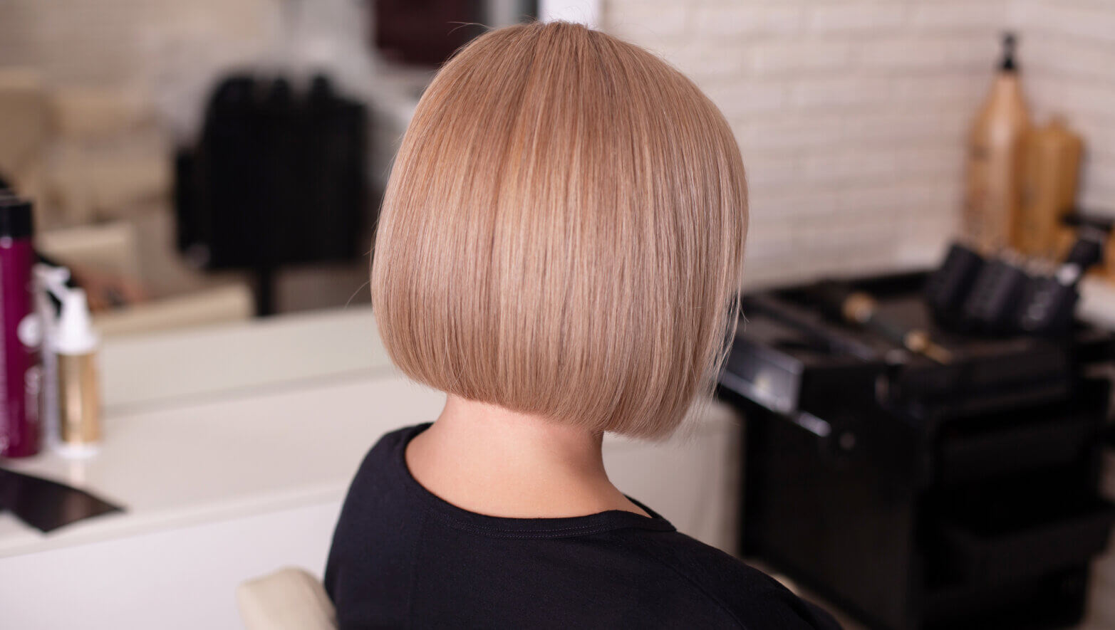 Female back with short natural blonde hair. Female back with short straight natural blonde hair in hairdressing salon