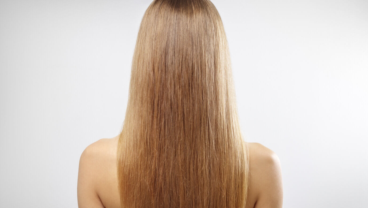 Girl with beautiful straight hair on a gray background