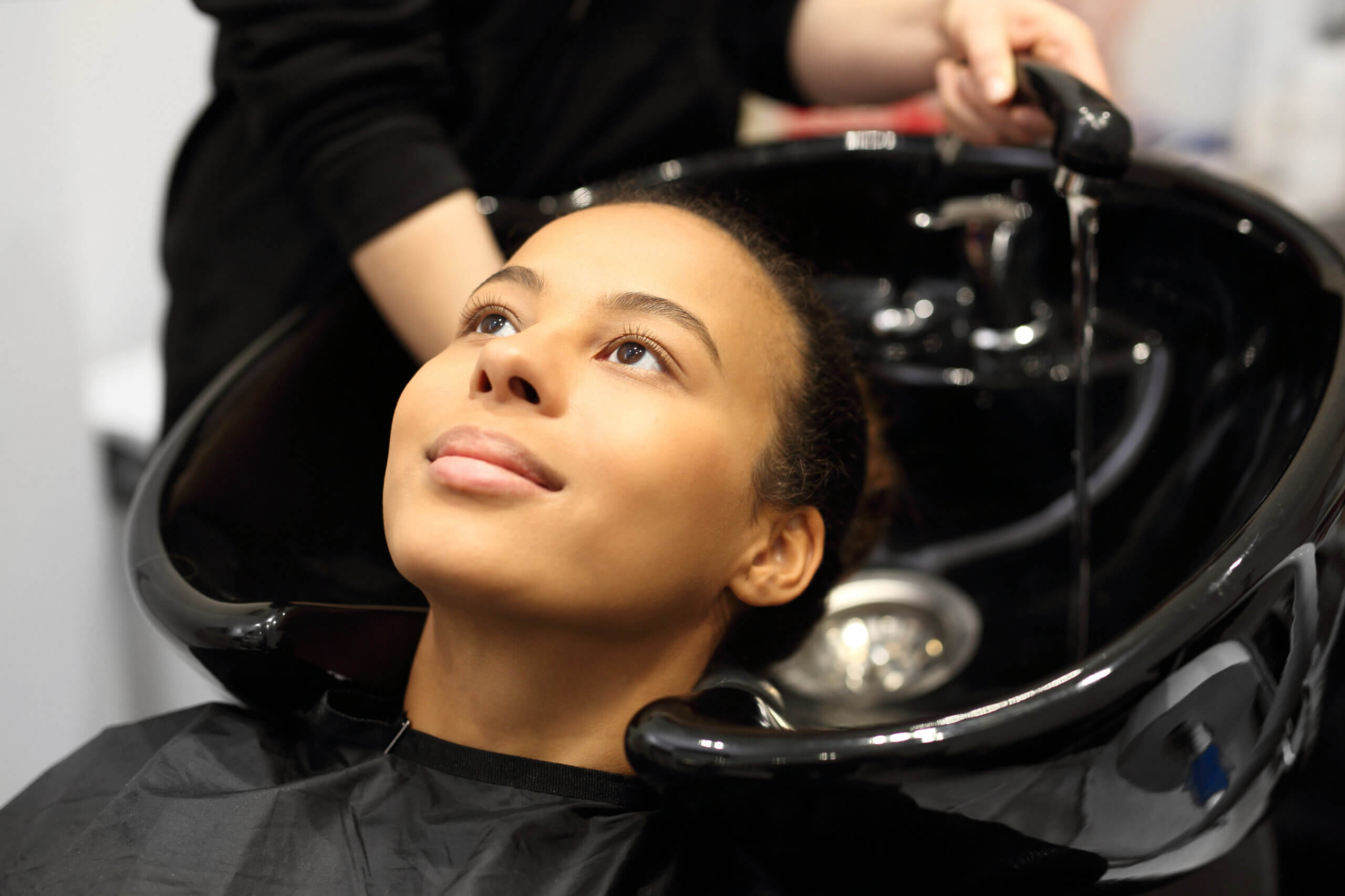 Washing head in a hair salon. Hairdresser washing hair women in a hair salon