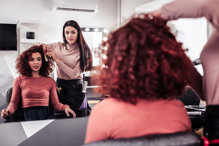 stylist consults client with curly hair